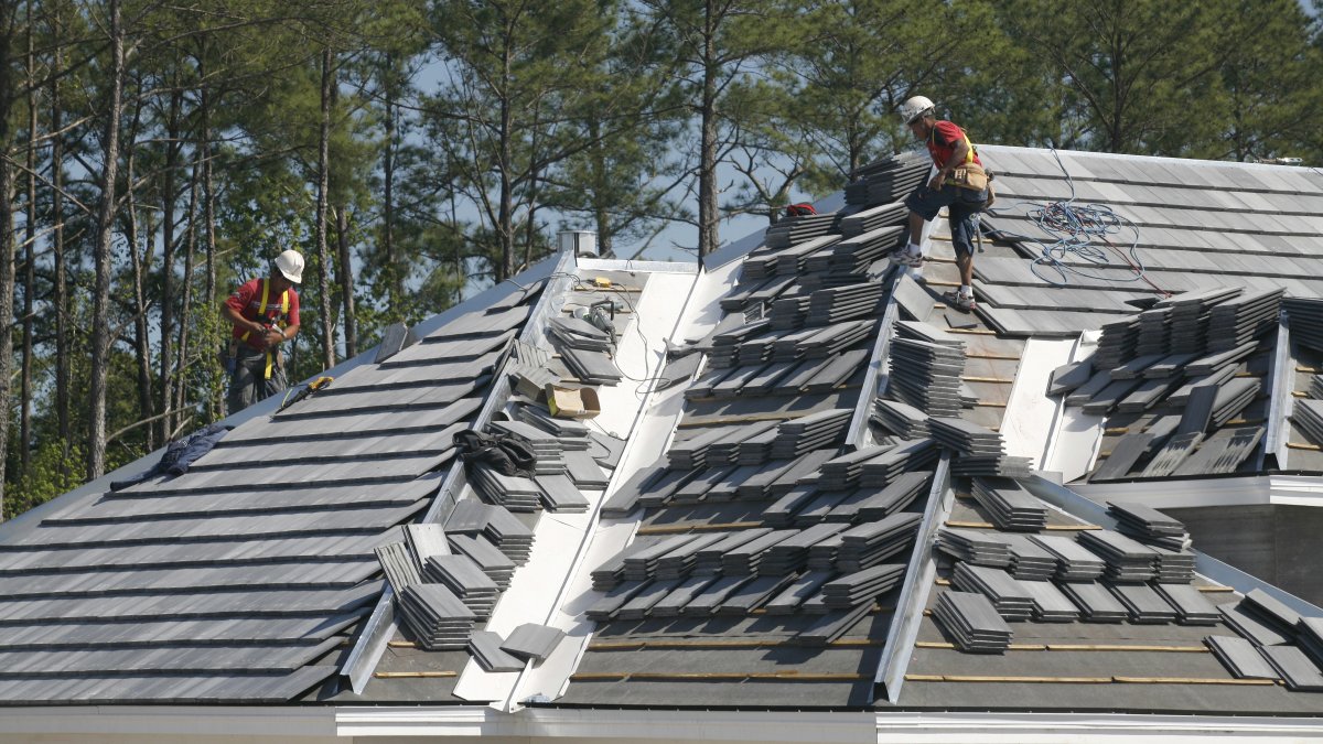 workers installing roofing tiles