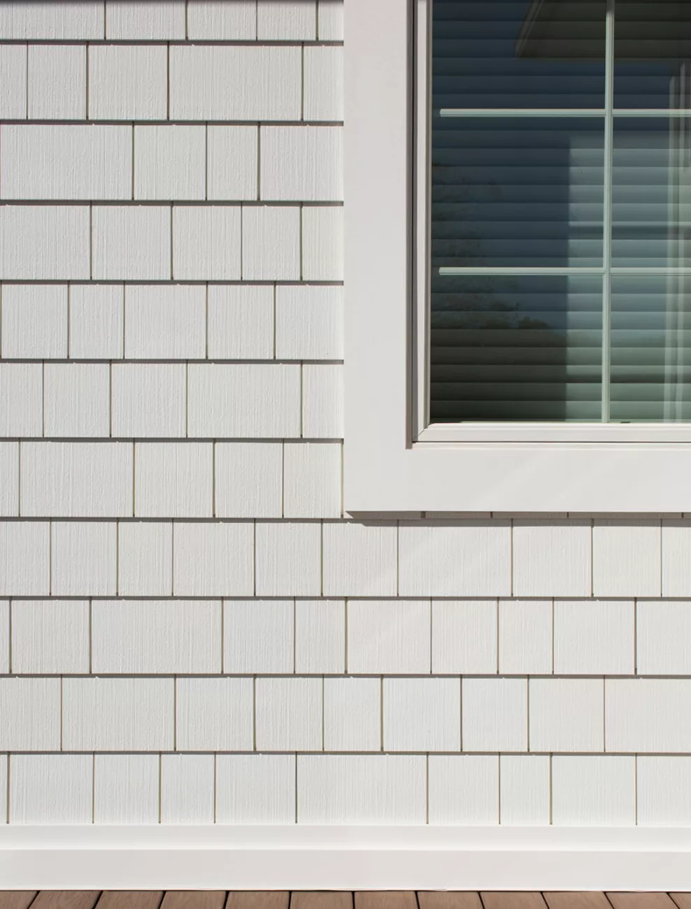 close up of a home with white siding and a window