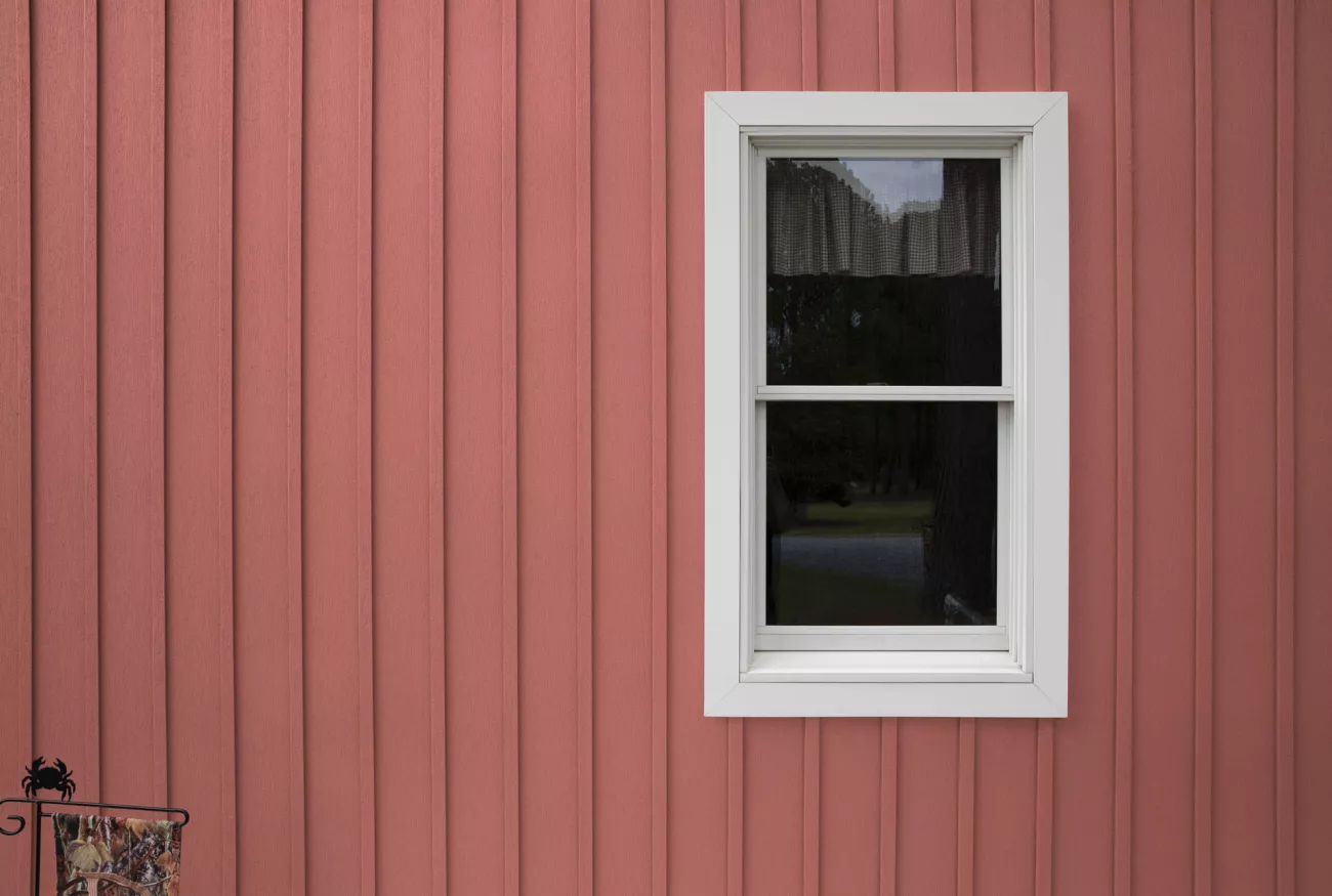 close up shot of a red barn-style building with a window