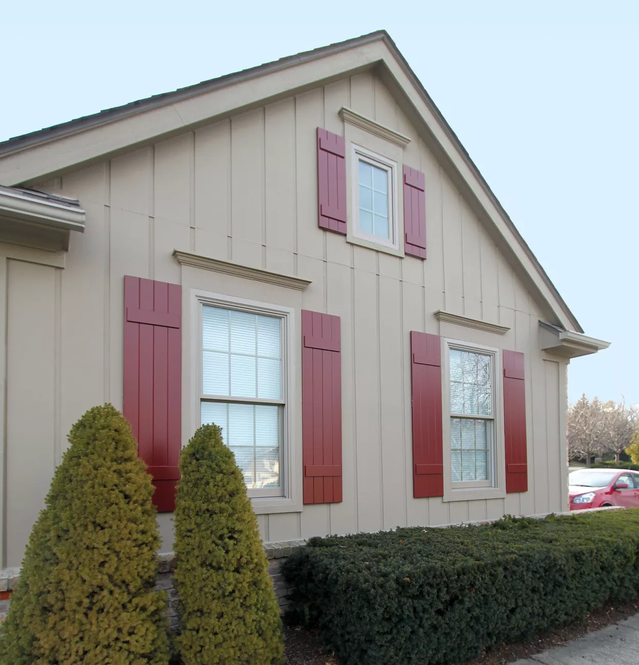 classic red board and batten shutters on a barn-style home